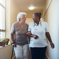 nurse walking with woman in hallway