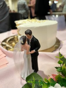 wedding topper with bride and groom in front of wedding cake